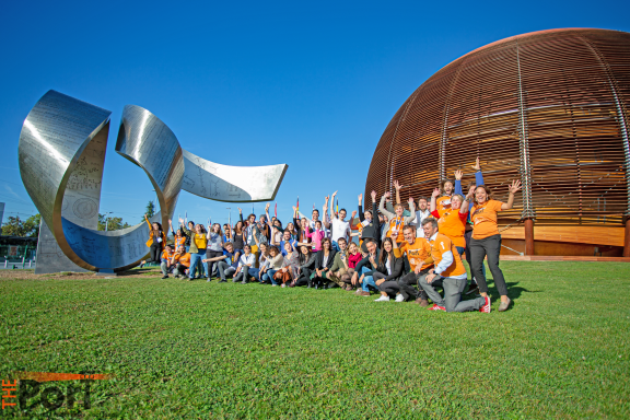 A group of people waving in front of CERN's Globe building
